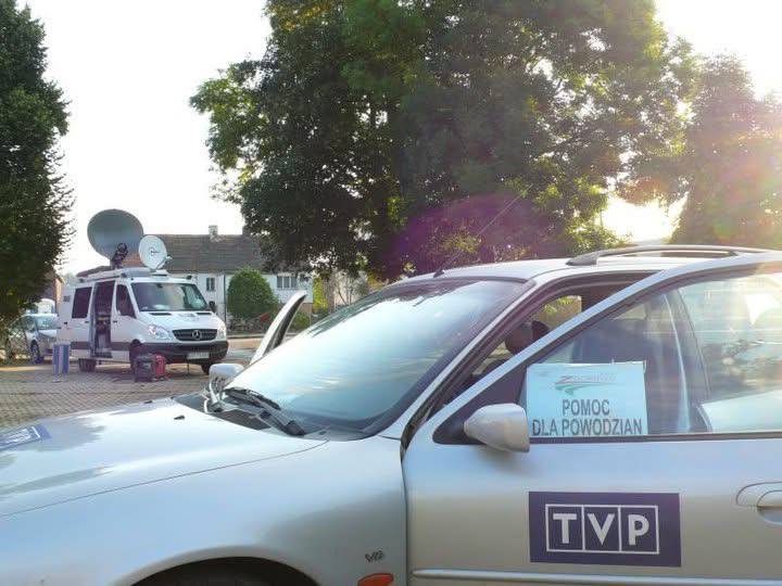 Samochód TVP3 Wrocław z kartką „Pomoc dla powodzian” oraz wóz transmisyjny w tle podczas powodzi 1997 roku