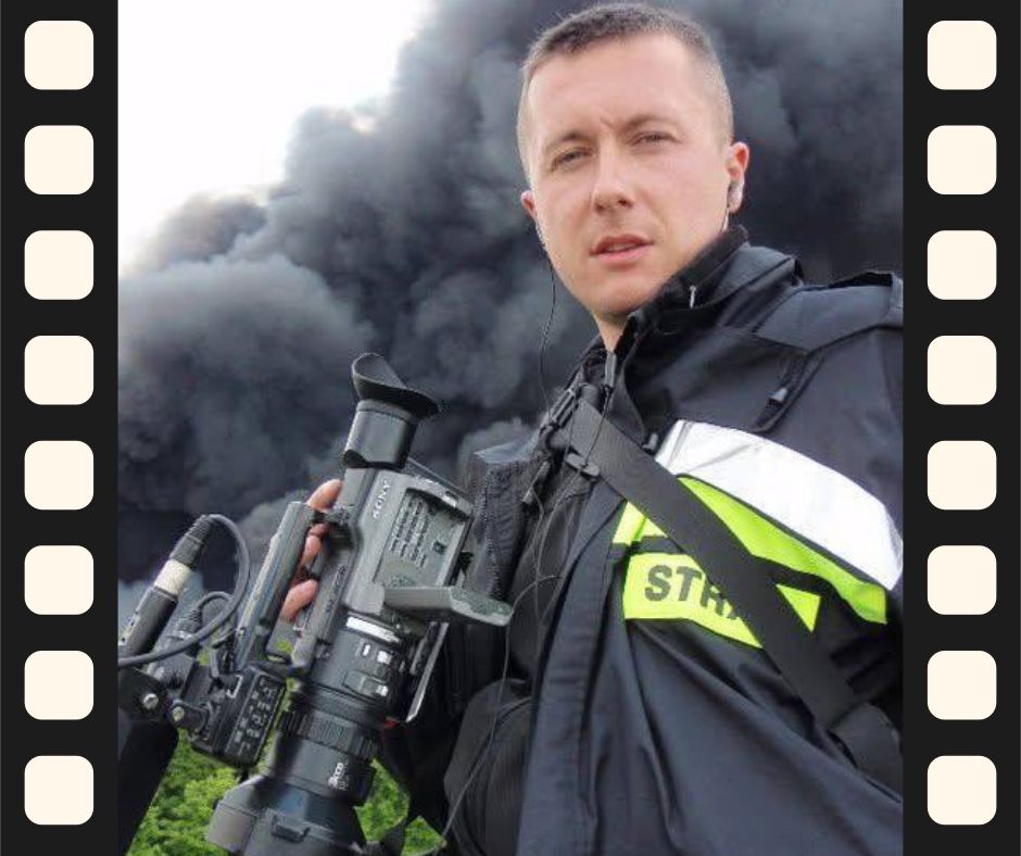 Marcin Brodowski w kamizelce „STRAŻ” z kamerą, podczas nagrywania relacji z pożaru dla TVP3 Wrocław