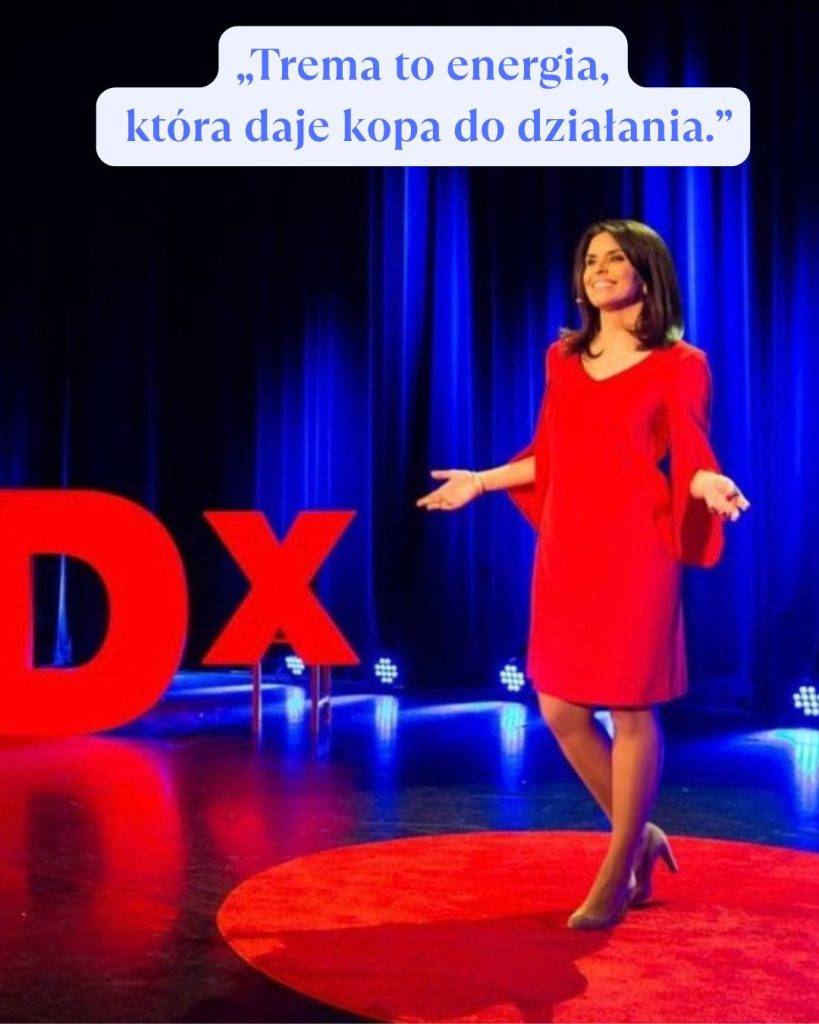 Dr Elena Pawęta na scenie TEDx w czerwonej sukience, dzieląca się inspirującym przesłaniem o tym, że trema to energia, która daje kopa do działania