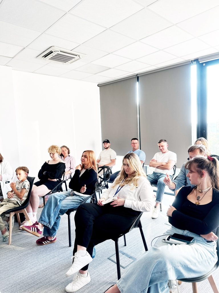 Uczestnicy panelu dyskusyjnego podczas spotkania „Środa w TS” w Fundacji Twój StartUp we Wrocławiu. Publiczność aktywnie słucha i notuje.