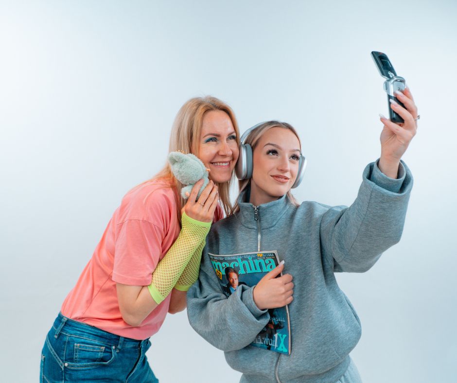 Millenialsi i Gen Z robią wspólne selfie, symbolizując zmieniające się pokolenia i wpływ technologii na biznes